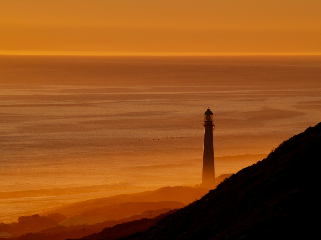 Faro antiguo en la costa neblinosa de Cabo Polonio al atardecer